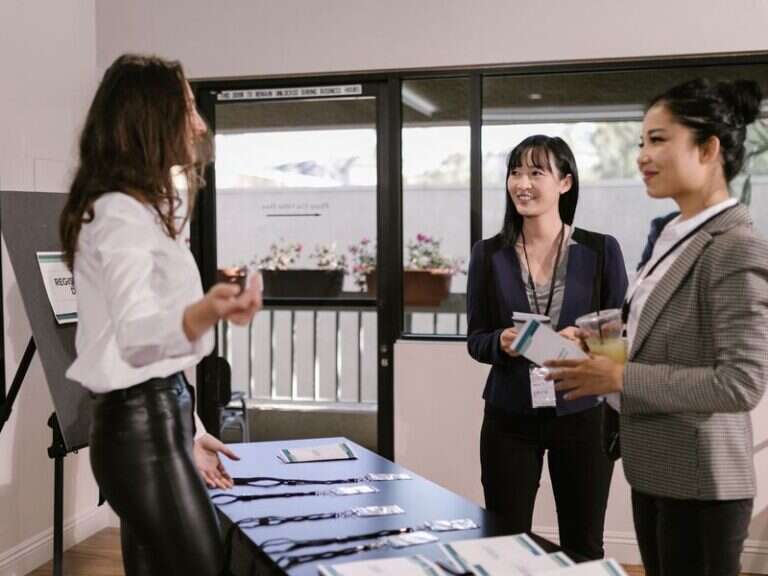 Delegates collecting badges at a conference registration desk